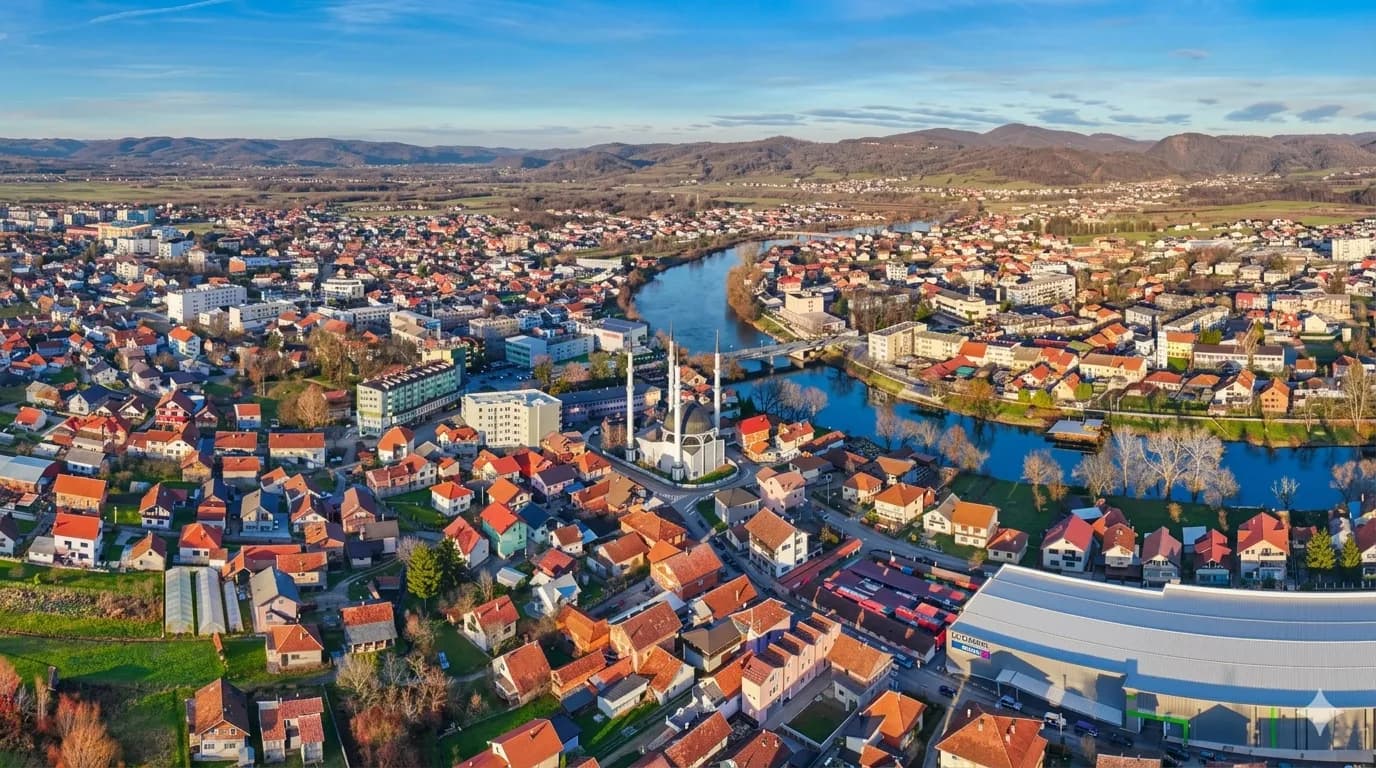 Flygvy över Sanski Most med moskén och floden Sana en klar vårdag